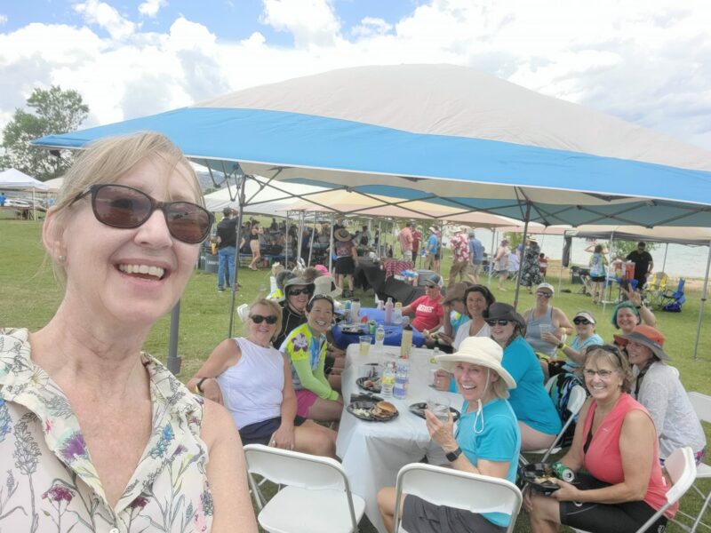 Karen Cobb with Venus sisters seated and smiling at a table under a tent