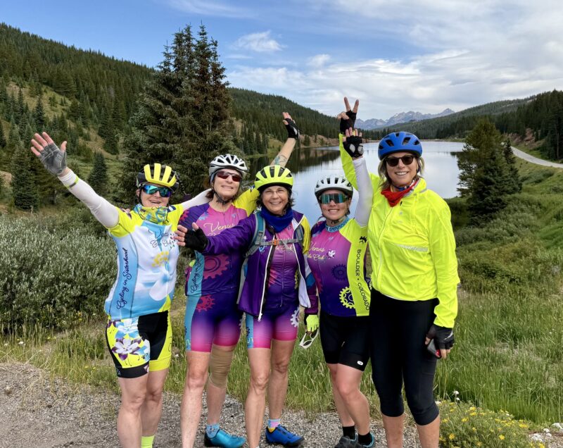 Five Venus sisters posing in front of a lake and mountains