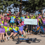 Venus Bike Club members with donation prop check