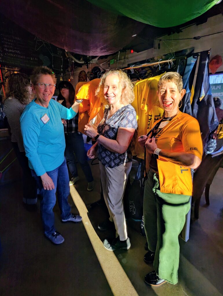 Venus members standing in front of a rack of sample cycling kits to try on