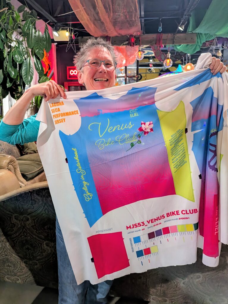 Venus sister holding up sample fabric for new cycling kits